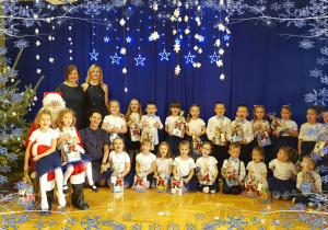 Dzieci z Mikołaje, panią Olą, Agnieszką i Gosią na tle zimowej dekoracji